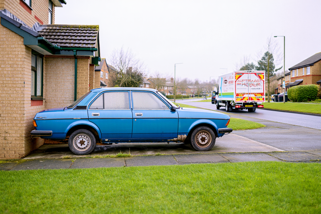 Non-runner car on a driveway before deciding whether to scrap or transport.