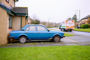 Non-runner car on a driveway before deciding whether to scrap or transport.